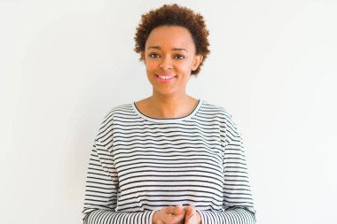 Beyaz arka planda çizgili kazak giyen genç güzel Afrikalı Amerikalı kadın el ve parmaklar birlikte rahat ve neşeli gülümseyen geçti. Başarı ve iyimserlik