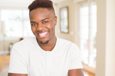 Büyük bir gülümseme ile neşeli gülümseyen yakışıklı Afrikalı genç adam 