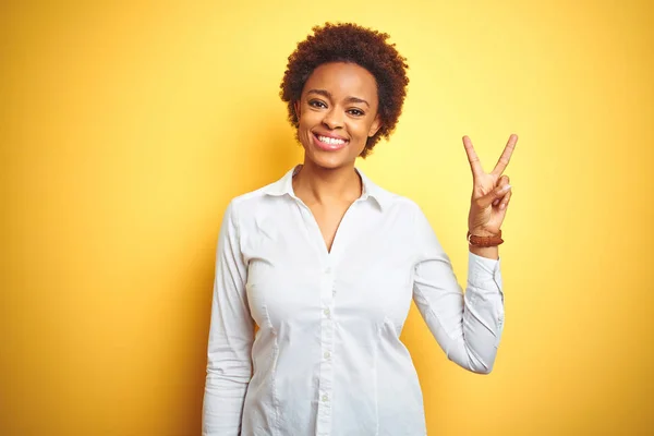 孤立した黄色の背景の上にアフリカ系アメリカ人のビジネスウーマンは 自信と幸せに微笑みながら 指ナンバー2で示し 指を指差す — ストック写真