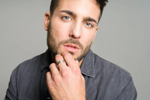 Joven hombre guapo posando y modelando sobre gris aislado backg —  Fotos de Stock