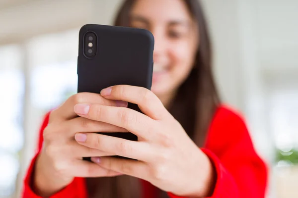 Νεαρή γυναίκα που χρησιμοποιεί smartphone, χαμογελαστά χαρούμενα μηνύματα και δακτυλογράφηση — Φωτογραφία Αρχείου