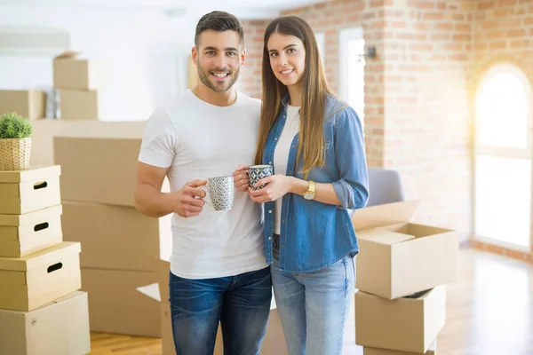 Mooi paar verhuizen naar een nieuw huis, glimlachend vrolijk Drinkin — Stockfoto