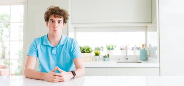 Evde dudakları, çılgın ve komik jest ile balık yüz yapma genç yakışıklı adam geniş çekim. Komik ifade.