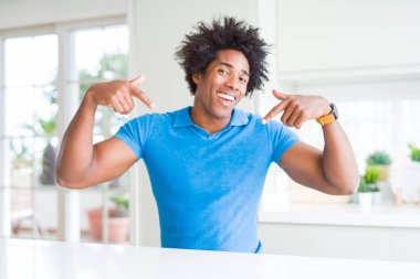 Afro-Amerikan evde kendini gururlu ve mutlu parmakları ile işaret emin yüz, gülümseme ile seyir.