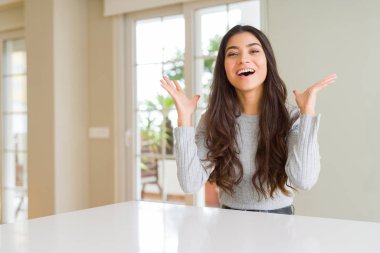 Genç güzel kadın evde deli ve başarı için hayran kaldırdı kollarını açarak kutluyor ve heyecanlı çığlık gözleri açık. Kazanan kavramı
