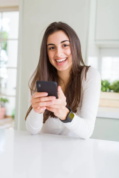 Jovem mulher usando smartphone, sorrindo mensagens de texto felizes e digitação — Fotografia de Stock