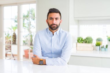 Yakışıklı İspanyol iş adamı şüpheci ve sinir, onaylamayan ifade yüz çapraz kolları üzerinde. Negatif kişi.