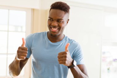 Yakışıklı African genç adam yapıyor thumbs yukarı jest, büyük symbol