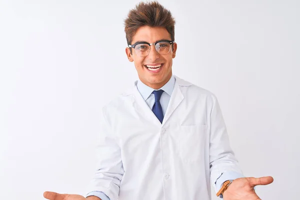 年轻的帅哥男子戴着眼镜 披着外衣 在孤立的白色背景上微笑着 张开双臂 作为友好的欢迎 积极和自信的问候 — 图库照片