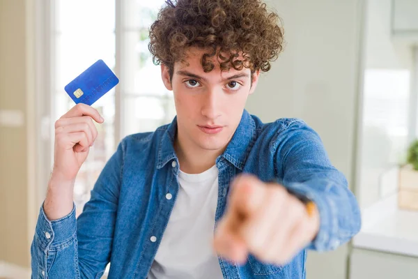 Joven Sosteniendo Tarjeta Crédito Señalando Con Dedo Cámara Usted Signo —  Fotos de Stock