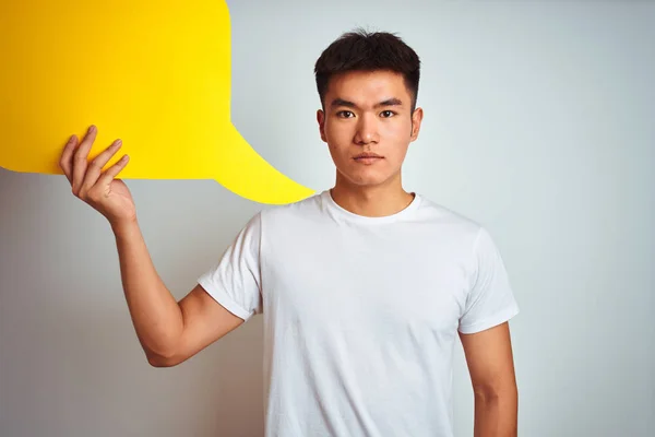 亚洲华裔男子抱着演讲泡泡站在孤立的白色背景与自信的表情在聪明的脸思考认真 — 图库照片