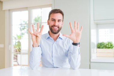 Yakışıklı iş adam gösteren ve parmak numarası dokuz ile işaret ederken emin ve mutlu gülümseyen.