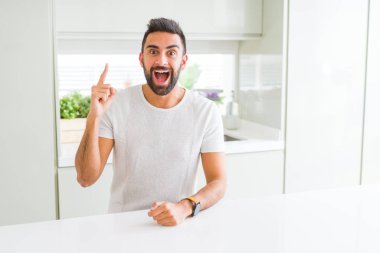 Yakışıklı İspanyol başarılı fikir kadar rahat beyaz t-shirt ev işaret parmağı, dostum. Çıktıktan ve mutlu. Bir numara.