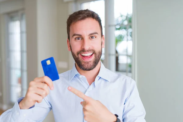 Hombre Negocios Guapo Sosteniendo Tarjeta Crédito Muy Feliz Señalando Con —  Fotos de Stock