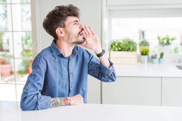 Hombre Joven Con Camisa Casual Sentado Mesa Blanca Gritando Gritando — Foto de Stock