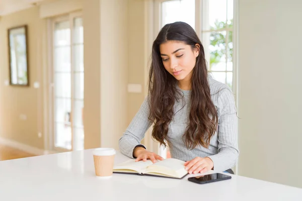 Mujer Joven Leyendo Libro Bebiendo Café Con Una Expresión Confianza —  Fotos de Stock