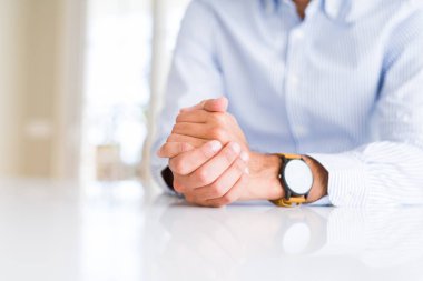 Beyaz masa üzerinde çapraz eller ile adam yakın
