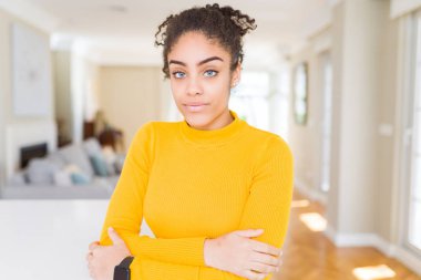 Yüzünde ciddi bir ifade ile afro saçlı gevşek güzel genç Afro-Amerikan kadın. Basit ve çapraz silah ile doğal