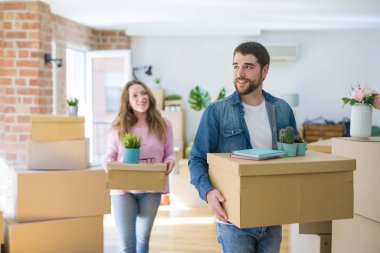 Yeni bir ev taşımak karton kutular tutarak birlikte çok mutlu genç güzel çift