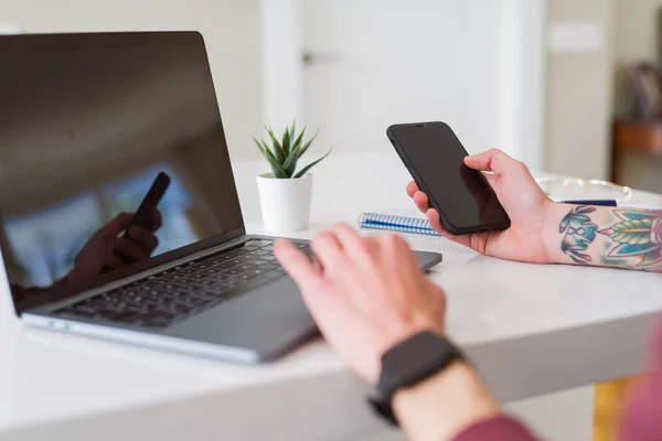 Hombre de negocios que trabaja con computadora portátil y teléfono inteligente, showi —  Fotos de Stock