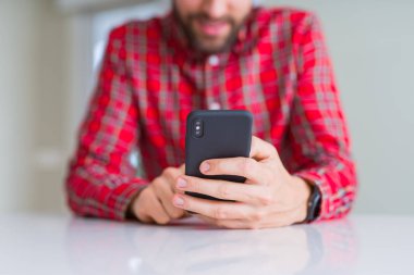 Smartphone kullanarak ve gülümseyen adam elinde yakın çekim