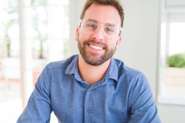 Gözlük takan ve gülümseyen yakışıklı adam kameraya rahat