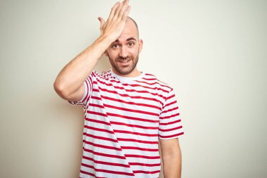 Beyaz izole arka plan üzerinde rahat çizgili kırmızı t-shirt giyen sakal ile genç kel adam hata için baş el ile şaşırdı, hatayı hatırlıyorum. Unuttum, kötü bellek kavramı.