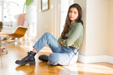 Şüpheci ve sinir, onaylamayan ifade yüz çapraz kolları üzerinde evde katta oturan genç güzel kadın. Negatif kişi.