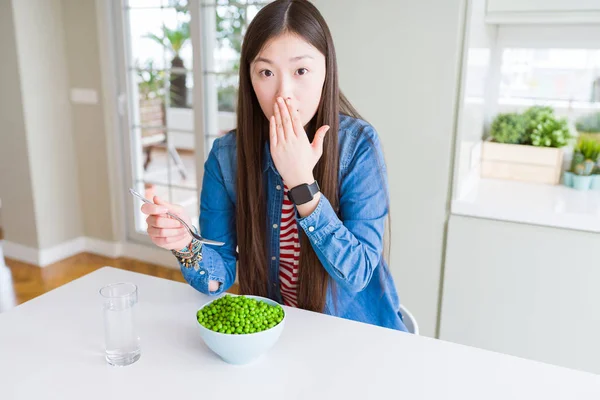 新鮮な緑のエンドウ豆カバー口を食べる美しいアジアの女性は 間違いの恥ずかしさ 恐怖の表現 沈黙で怖がって 秘密の概念でショックを受けた手で口を覆います — ストック写真