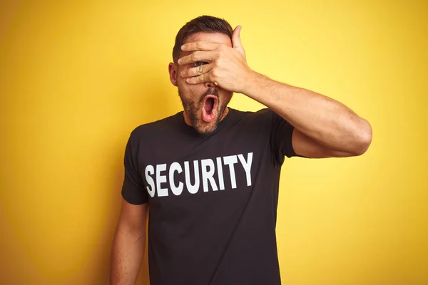 Giovane Uomo Salvaguardia Indossa Uniforme Sicurezza Sfondo Giallo Isolato Sbirciando — Foto Stock