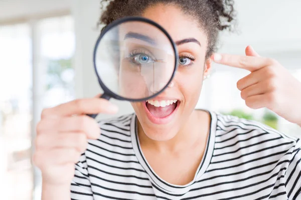 Mujer Afroamericana Joven Mirando Través Lupa Muy Feliz Señalando Con —  Fotos de Stock