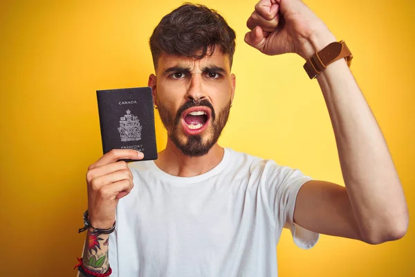 Jovem Com Tatuagem Vestindo Passaporte Canadense Sobre Fundo Amarelo Isolado — Fotografia de Stock