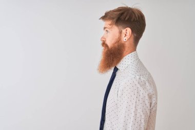 Genç kızıl saçlı İrlandalı işadamı yan bakarak izole beyaz arka plan üzerinde duran, doğal yüz ve kendine güvenen gülümseme ile profil poz dinlenmek.