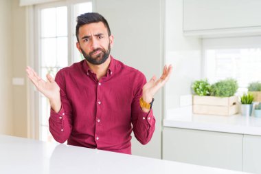 Yakışıklı İspanyol iş adamı habersiz ve karışık ifade kollar ve eller kaldırdı. Şüphe kavramı.