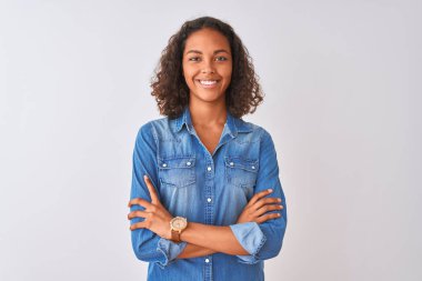 Genç Brezilyalı kadın kamera bakıyor Çapraz kollar ile gülümseyen izole beyaz arka plan üzerinde ayakta denim gömlek giyiyor. Pozitif kişi.