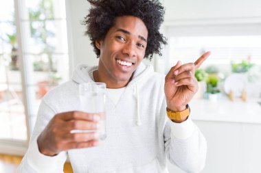 Afrika kökenli Amerikalı adam eve çok mutlu el ve parmak ile tarafına işaret su içme