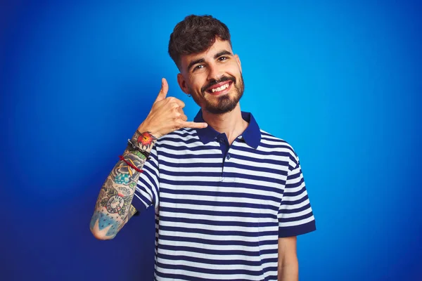 Jovem Com Tatuagem Vestindo Pólo Listrado Sobre Fundo Azul Isolado — Fotografia de Stock