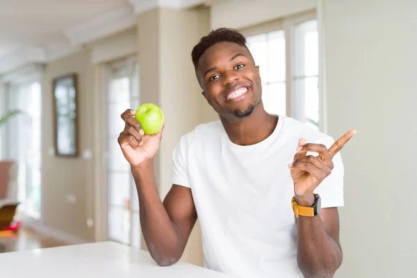 Joven Hombre Afroamericano Comiendo Manzana Verde Fresca Muy Feliz Señalando — Foto de Stock