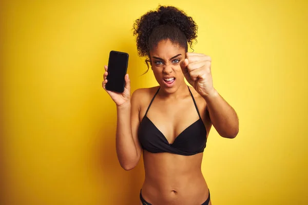 Zole Sarı Arka Plan Üzerinde Akıllı Telefon Gösteren Bikini Giyen — Stok fotoğraf
