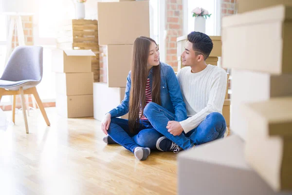 Young asian couple sitting on the floor of new house arround car