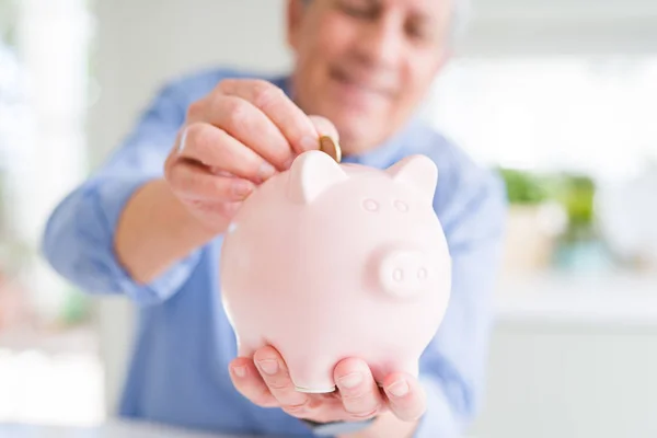 Człowieka Wprowadzenie Monety Wewnątrz Piggy Bank Jako Uśmiechający Się Oszczędności — Zdjęcie stockowe