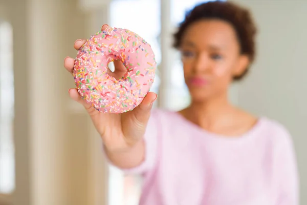 Mujer Afroamericana Joven Comiendo Rosado Donut Azúcar Con Una Expresión —  Fotos de Stock