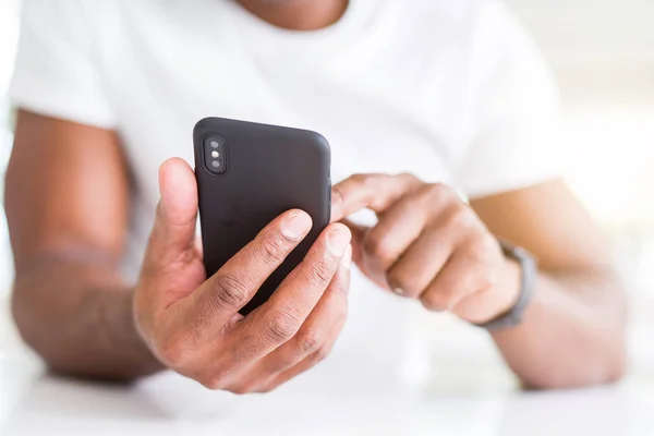 Close up de mãos homem americano Africano usando smartphone — Fotografia de Stock