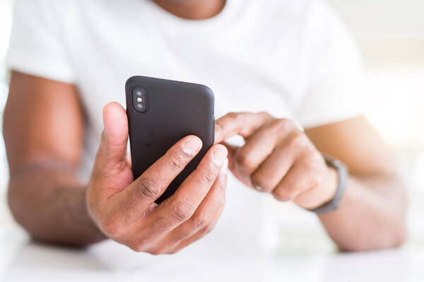 Close up of african american man hands using smartphone