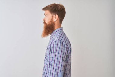 Genç Kızıl İrlandalı adam rahat gömlek ayakta izole beyaz arka planda duran yan arıyor, rahat bir gülümseme ile doğal yüzü ile profil poz rahatlayın.