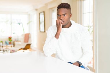 Beyaz tablo üzerinde yakışıklı Afrikalı Amerikalı adam vurguladı ve ağız ısırma çivi elleri ile gergin bakıyor. Anksiyete sorunu.