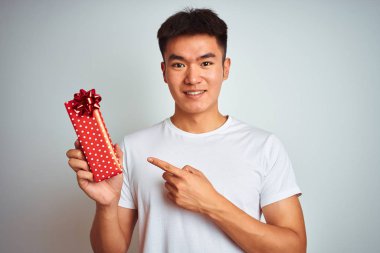 Genç Asya Çinli adam tutan Sevgiliye mevcut ayakta üzerinde izole beyaz arka plan çok mutlu işaret ile el ve parmak