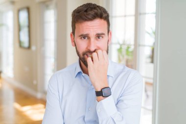 Yakışıklı iş adamı vurguladı ve ağız ısırma tırnakları ile gergin bakıyor. Anksiyete sorunu.