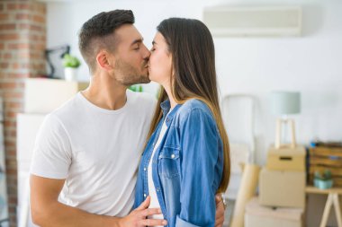 Güzel genç çift yeni bir eve hareket, mutlu civarı karton kutular gülümseyen