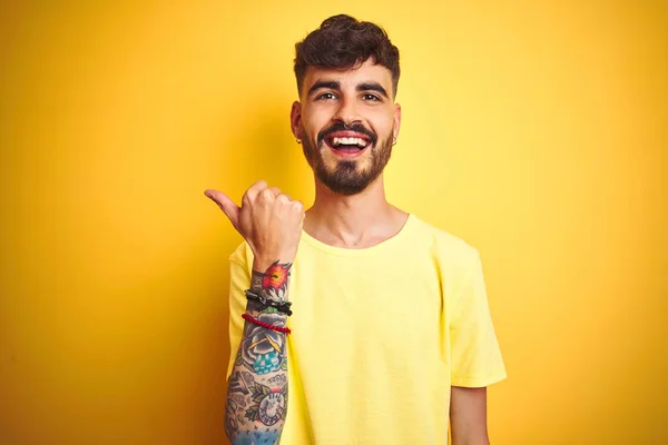 Mladý Muž Tetováním Tričku Stojící Nad Izolovaným Žlutým Pozadím Úsměvem — Stock fotografie